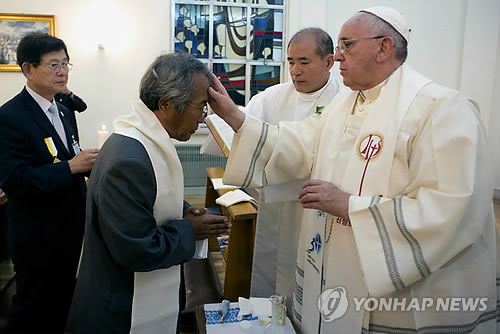 프란치스코 교황이 17일 오전 서울 종로구 궁정동 주한교황청대사관에서 세월호 참사로 숨진 단원고 학생 이승현 군의 아버지 이호진씨에게 세례성사를 하고 있다.