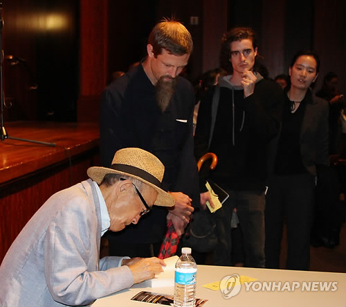 고은 시인이 시카고 해롤드 워싱턴 도서관내 신디프리츠커홀에서 시 낭송회를 마친 후 영문 시집 사인회를 하고 있다.