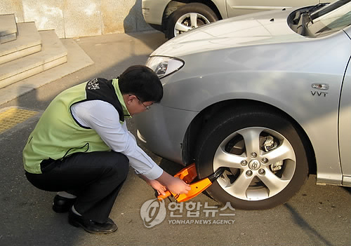 체납 대포차 바퀴에 족쇄를 채우는 모습.