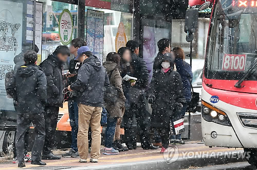 눈이 내린 1일 오전 시민들이 서울 중구 을지로의 한 버스정류장에서 버스를 기다리고 있다.