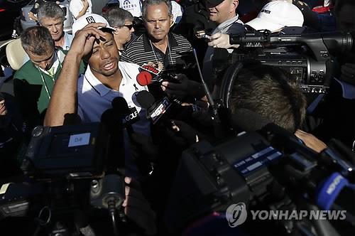 타이거 우즈가 기권한 뒤 기자들에게 둘러싸여 질문을 받고 있다. (AP=연합뉴스)