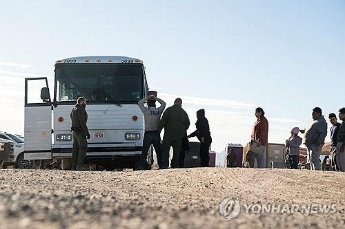 미국 남부 국경지대에서 이송 버스에 오르는 중남미 출신 불법입국자들