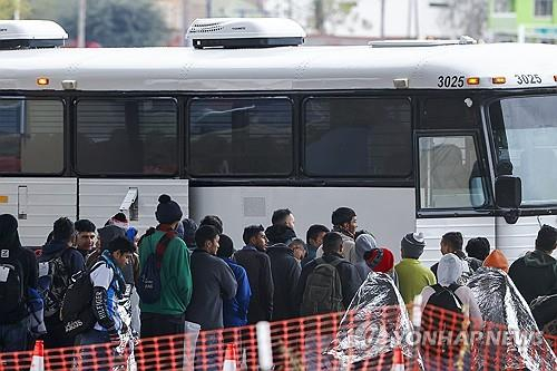 텍사스주 이글패스에서 이송버스 탑승을 기다리고 있는 중남미 출신 이주민들