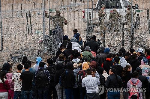 철조망 넘으려는 불법 이민자들과 이를 막는 국경순찰대