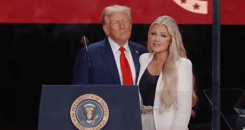 트럼프 대통령이 에리카 커그를 무대에서 맞이하고 있다.